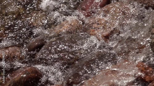 Slow motion of rapid water, falling and splashing over brown and red boulders. High speed camera shooting. Relax view for meditative intro. Natural beautiful background with amazing texture.
