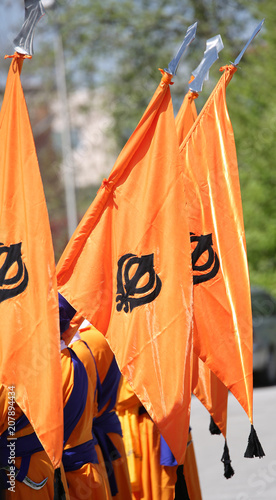 orange sikh flags with khanda symbol during a religiuous process photo