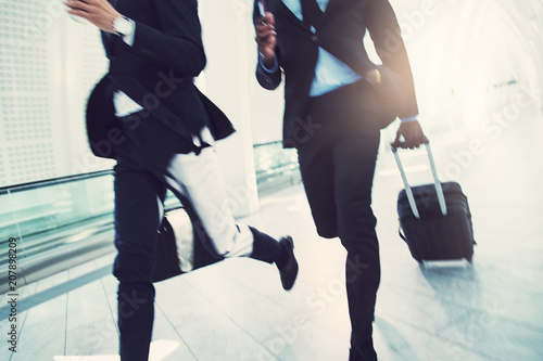 фотографія Two businessmen rushing through an airport to catch a flight