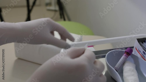 Nurse puts on bar code sticker on vacutainer after blood draw for identification photo