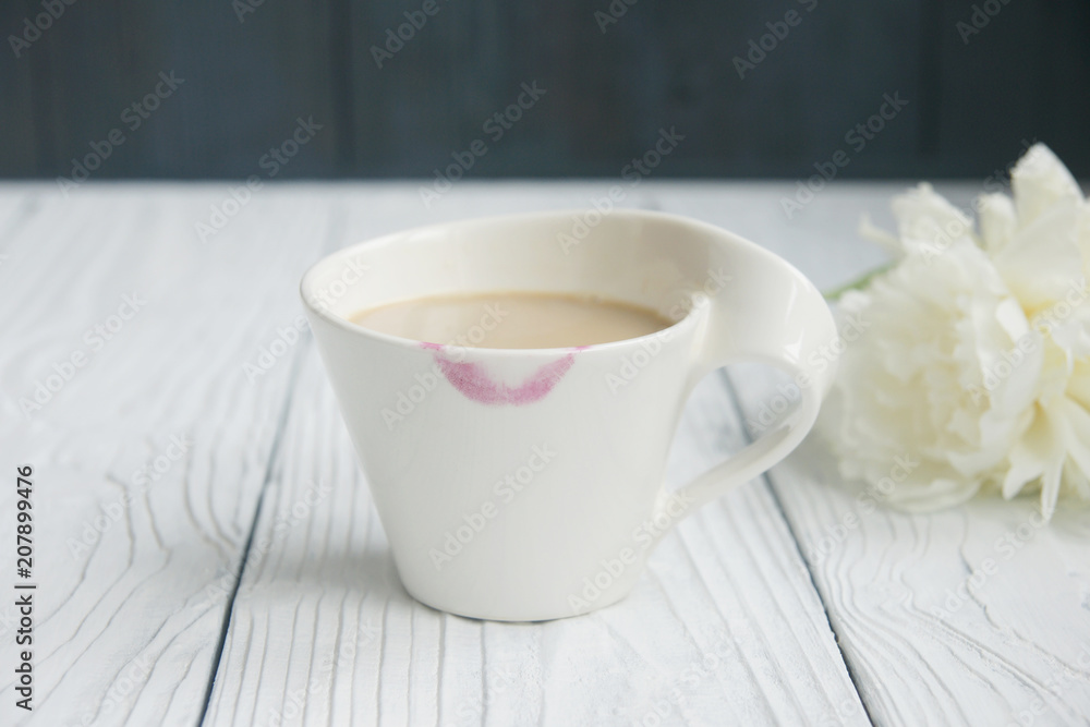 White cup of coffee on a white table with traces of lipstick
