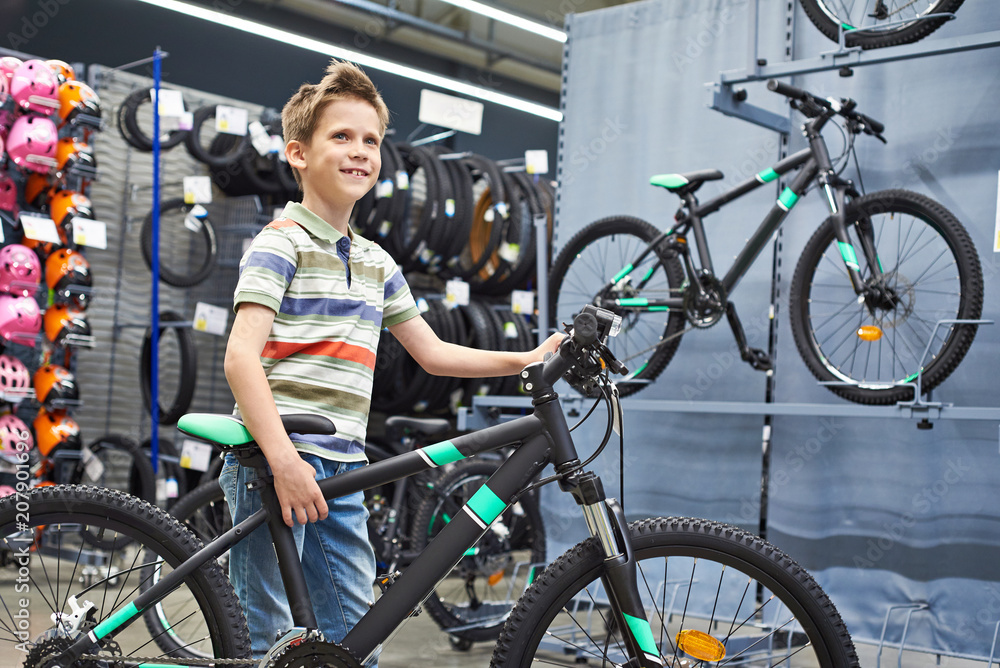 Obraz premium Boy and bicycle in sport shop