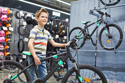 Boy and bicycle in sport shop