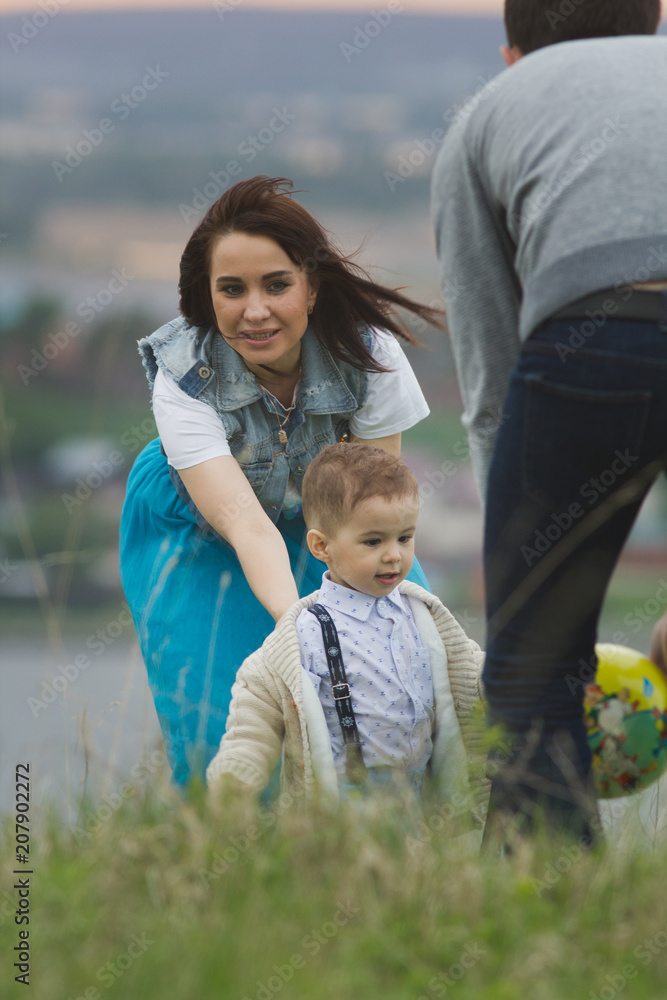 Young family with a child playing and having funat summer field Young family with a child playing and having funat summer field