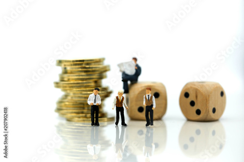 Miniature people businessman meeting with stack of coins and dices, risk of business concept.