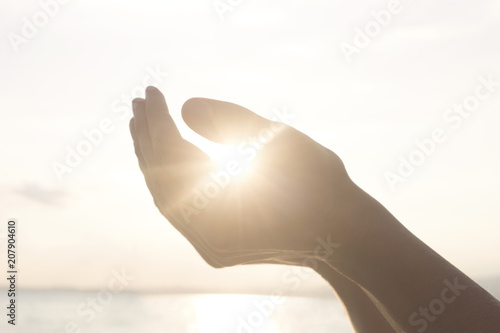woman's hands hold the sun and its energy