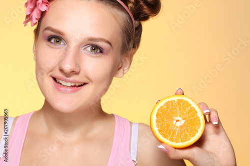 Young girl posing with halves of orange