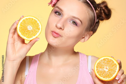 Young girl posing with halves of orange