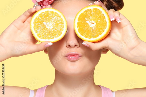 Young girl posing with halves of orange