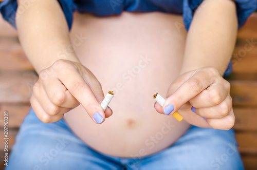 Stop Smoking Cigarettes. Pregnant Woman Holding Broken Cigarette in hands No Smoking Negative Nicotine Influence on Kids Problems of Conceiving Maternity © mykytivoandr