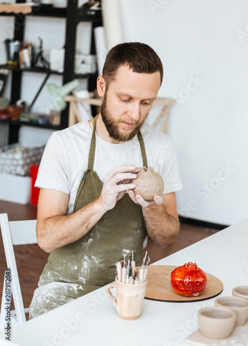 Ceramics master making order of one of clients by table