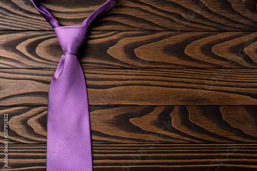 Canvas Print Purple necktie on an old wooden table. Close up