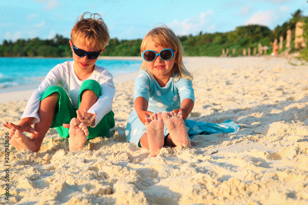 little boy and girl having fun play sand on beach little boy and girl having fun play sand on beach