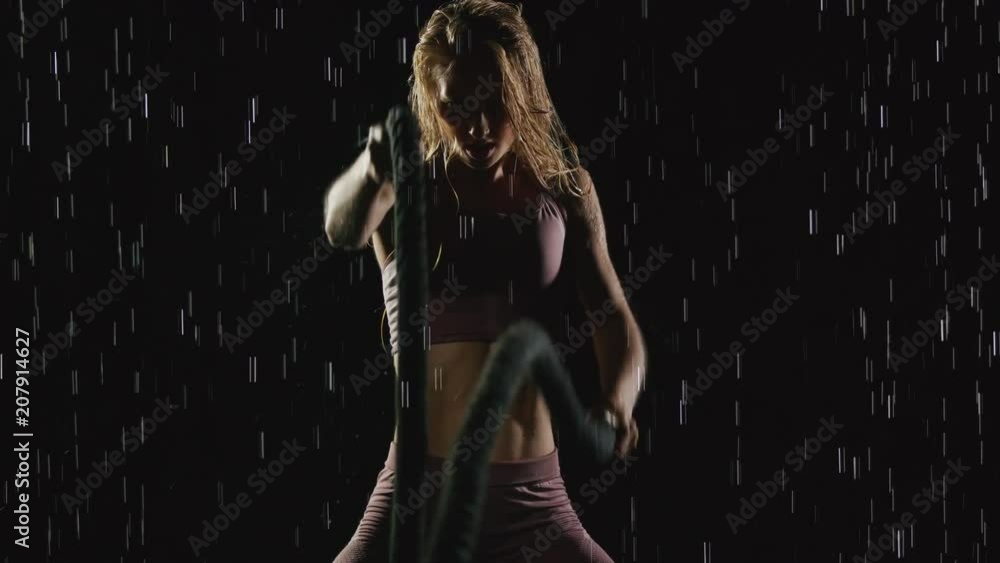 Athletic blond woman working out in the rain. Slow Motion Athletic blond woman working out in the rain. Slow Motion