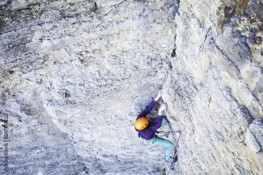 Man rock climber. Rock climber climbs on a rocky wall. Man makes hard move. Man rock climber. Rock climber climbs on a rocky wall. Man makes hard move.