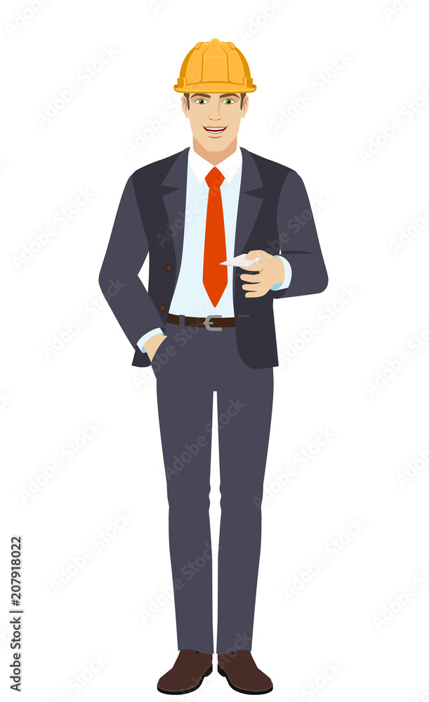 Businessman in construction helmet with hand in pocket gives a business card Businessman in construction helmet with hand in pocket gives a business card