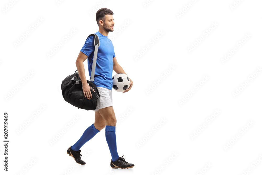 Soccer player with a bag and a football walking