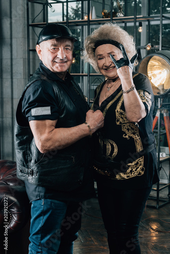 Happy couple of retirees in biker clothes.Senior man in black leather jacket and goggles.Biker grandmother and biker grandfather. Biker couple.