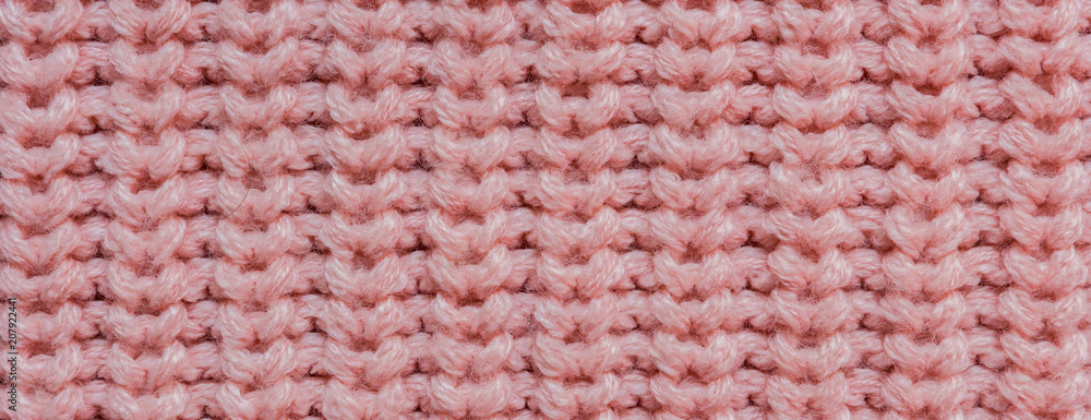 Texture of knitted background with a pattern of pink color close-up long banner Texture of knitted background with a pattern of pink color close-up long banner
