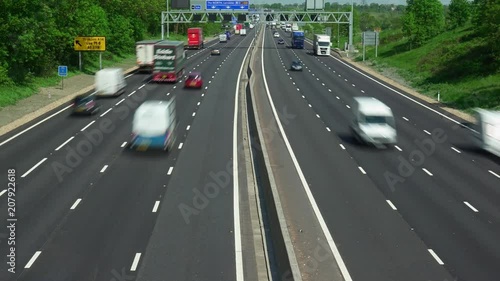 Time lapse of road traffic on the M1 smart four lane motorway with no hard shoulder and electronic active traffic management lane signs in Northamptonshire England. photo