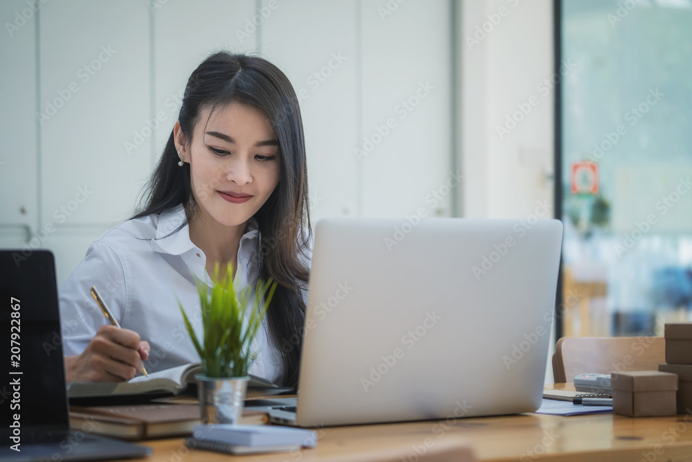 Beautiful businesswoman working with laptop at modern office Beautiful businesswoman working with laptop at modern office