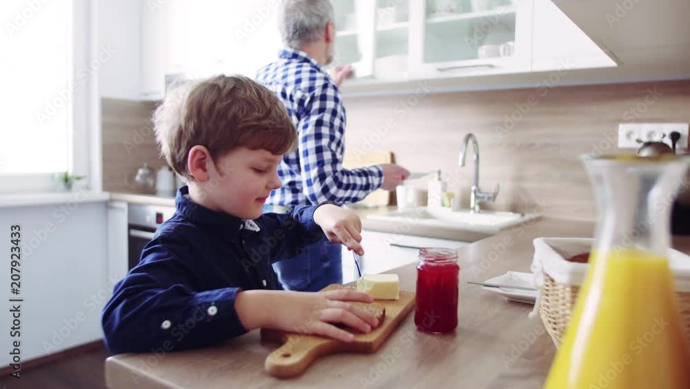 Senior grandfather with small grandson preparing food at home. Senior grandfather with small grandson preparing food at home.