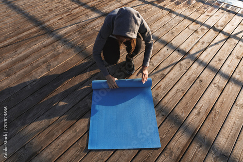Top view of a woman unwrapping fitness mat