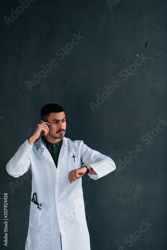 Portrait of confident male doctor with arms crossed standing at clinic.doctor in a medical dressing gown