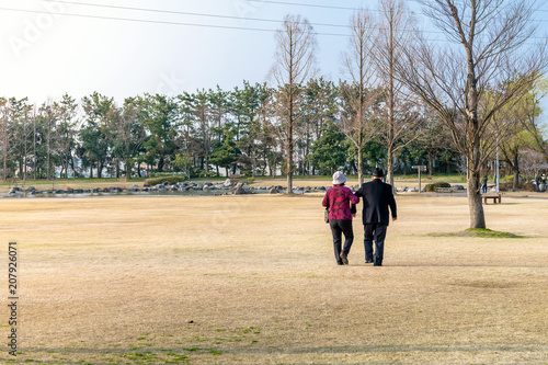 公園を腕組み歩く老夫婦