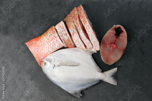 Фотография White pomfret Spanish mackerel red snapper fish cleaned descaled degutted sliced