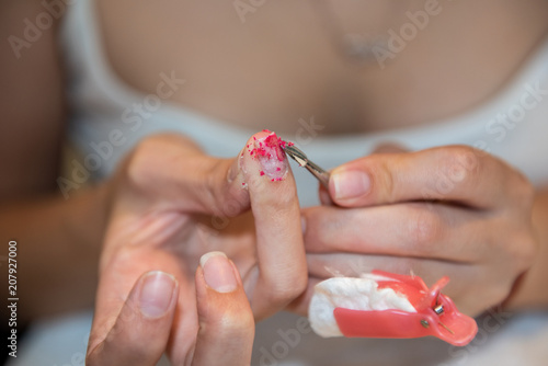 Removing nail polish with reusable plastic pinches and cotton pads soaked with acetone and nail spatula