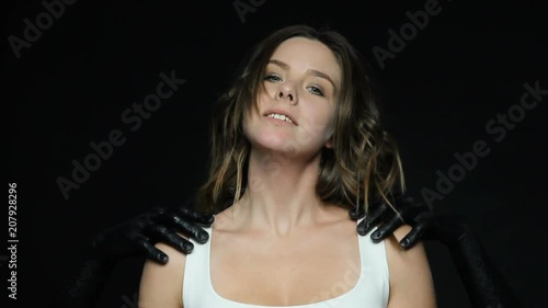 Black anonymous hands , symbolizing violence indicate to victim woman how to behave , the girl raised her chin, makes a synthetic smile, look to the camera photo