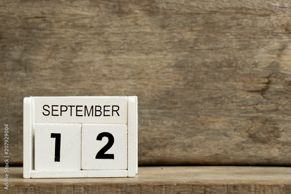 White block calendar present date 12 and month September on wood background White block calendar present date 12 and month September on wood background