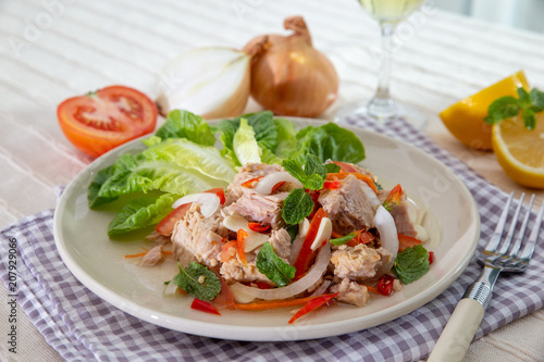 Spicy Tuna Salad onion and tomatoes in plate put on tabal , Thailand cuisine.
