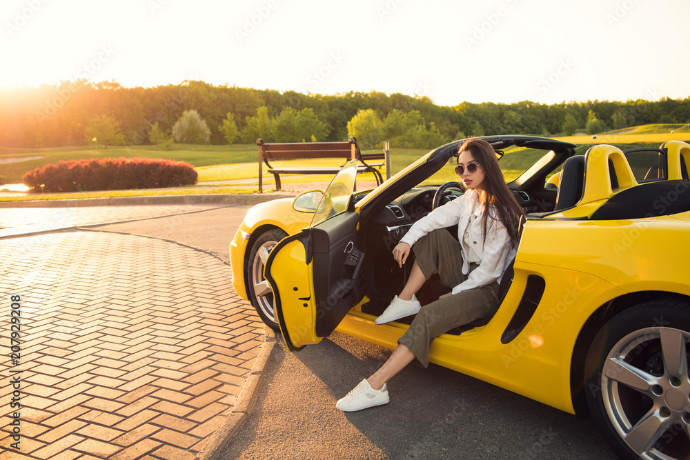 Ταπετσαρία Obsessed with the cars! Attractive serious perfect gorgeous young girl, while wearing glasses, sitting in the yellow cabrio and posing for the picture