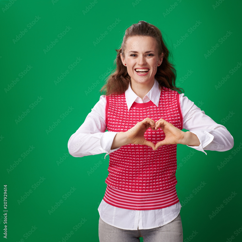 student woman showing heart shaped hands on green background student woman showing heart shaped hands on green background