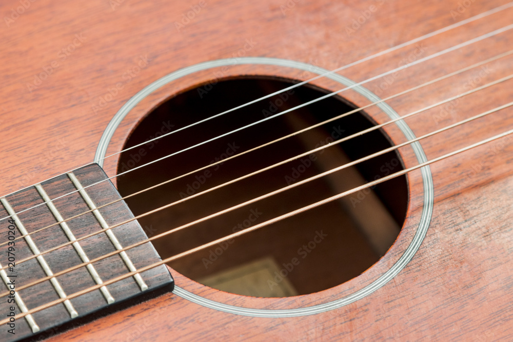 Close up of a red wooden acoustic guitar Close up of a red wooden acoustic guitar