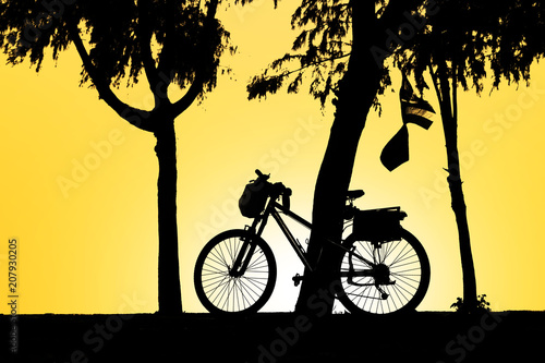 Silhouette of bicycle during sunrise in the park © rathchapon