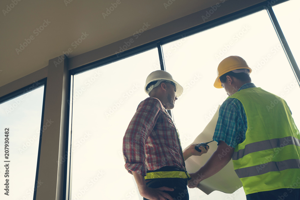 Male engineer talking with worker at a construction site. Male engineer talking with worker at a construction site.
