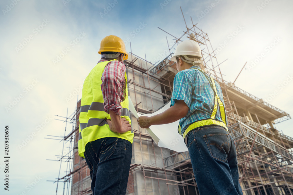 Male engineer talking with worker at a construction site. Male engineer talking with worker at a construction site.