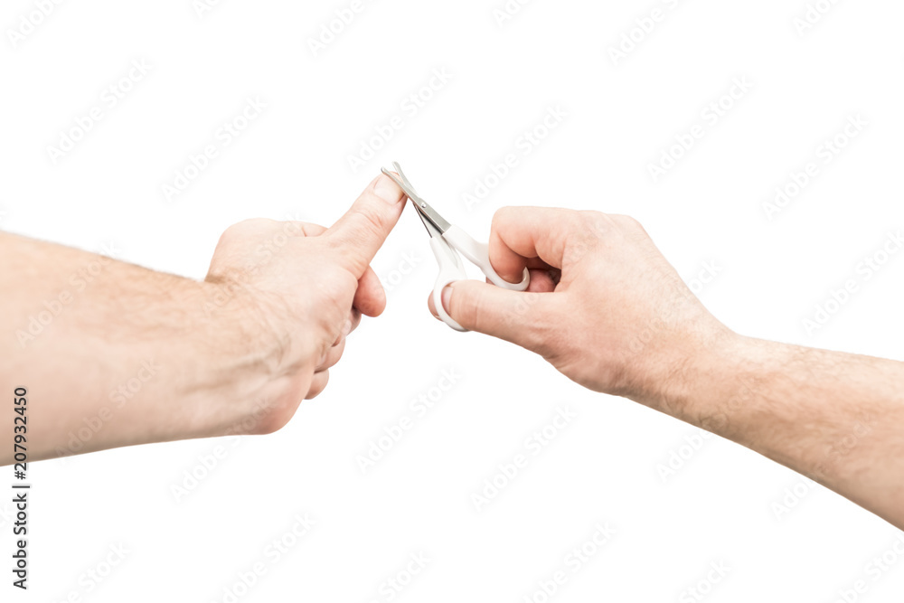 Male hand trimmed his nails on the thumb with small scissors, isolated on white background, first-person view