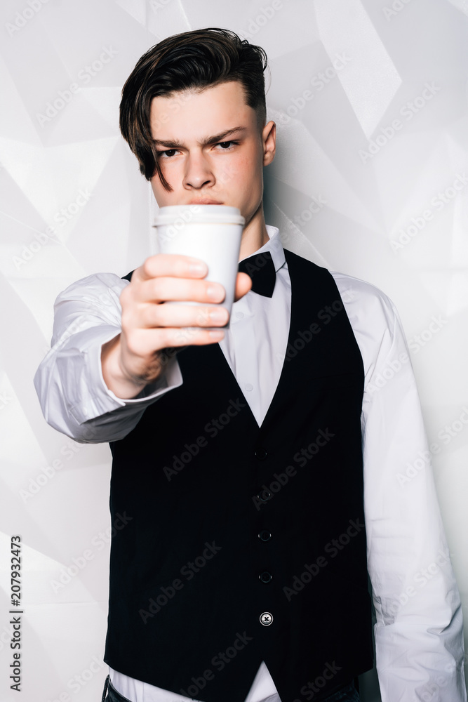 Wonderful drink. Cheerful nice man smiling and offering you tea while working as a waiter in the cafe. Coffee Business Concept.Portrait of waiter offering a cup of coffee in cafe Wonderful drink. Cheerful nice man smiling and offering you tea while working as a waiter in the cafe. Coffee Business Concept.Portrait of waiter offering a cup of coffee in cafe
