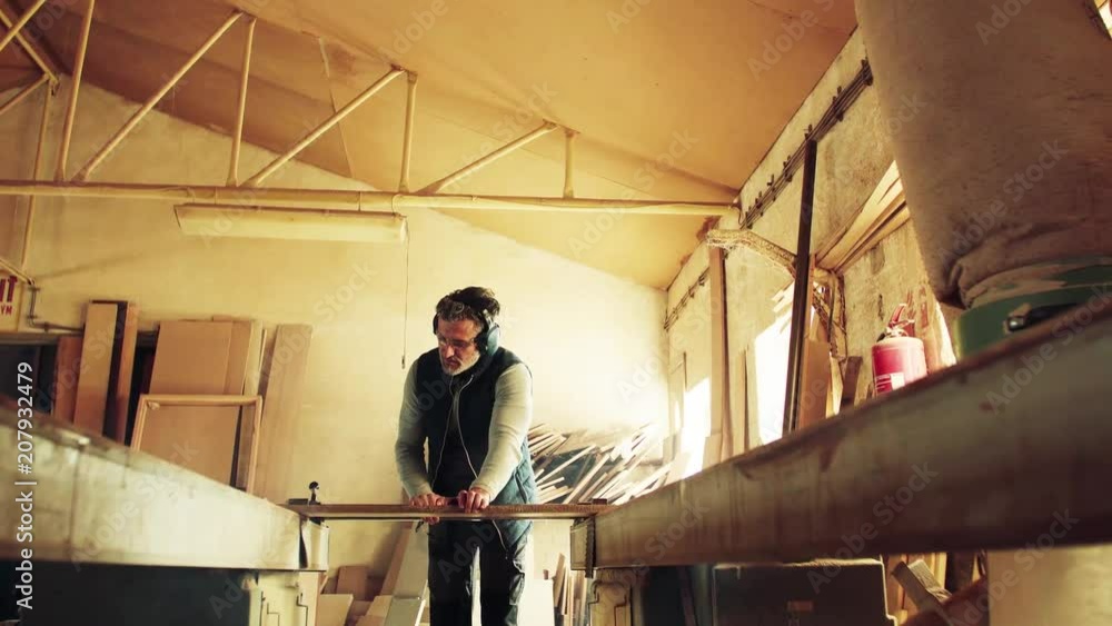 A man worker in the carpentry workshop, working with wood. A man worker in the carpentry workshop, working with wood.