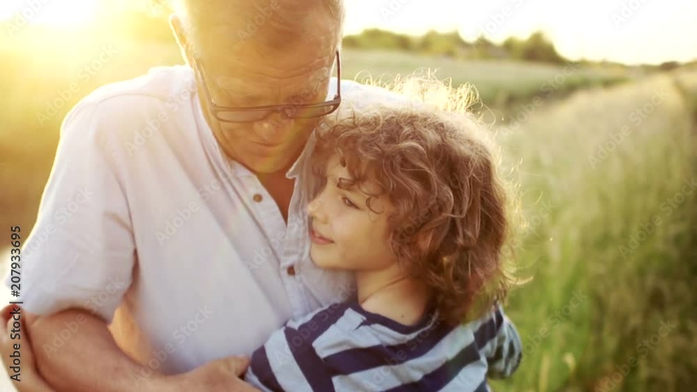 Grandfather hugs his grandson. A man teaches a boy to be strong. Male tenderness. Father's Day Grandfather hugs his grandson. A man teaches a boy to be strong. Male tenderness. Father's Day