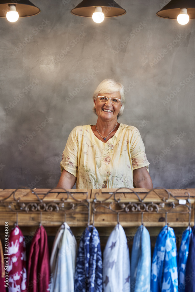 Portrait Of Senior Female Store Owner Standing Behind Cash Desk