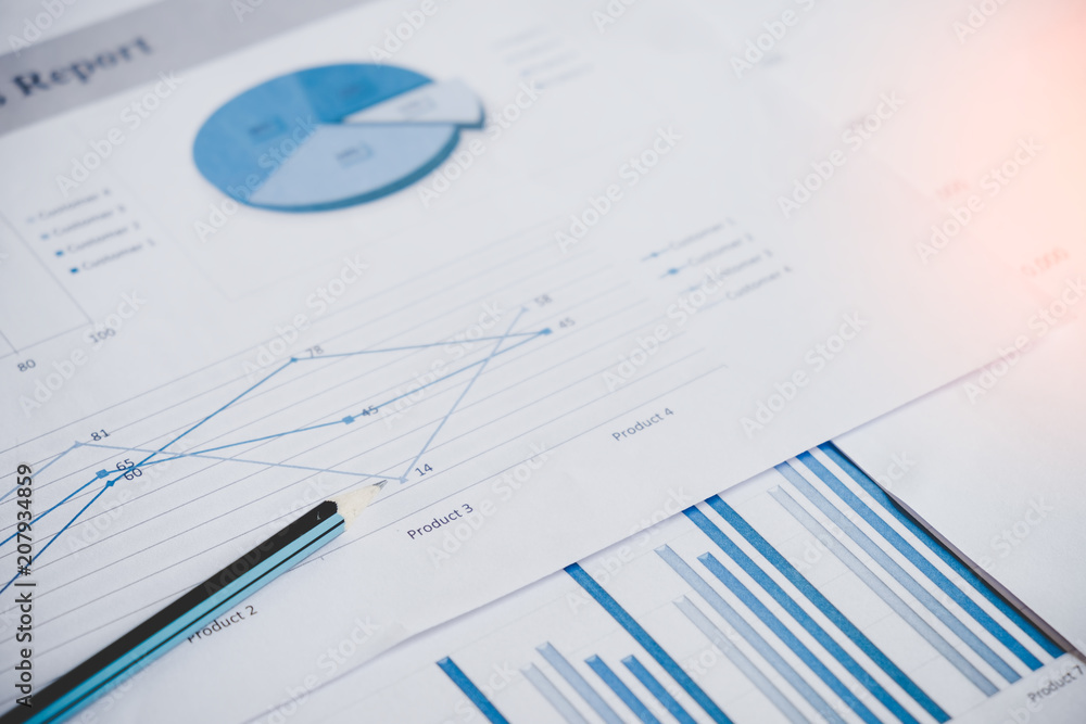 Many charts and graphs with pencil. Reflection light and flare. Concept image of data gathering and statistical working. Many charts and graphs with pencil. Reflection light and flare. Concept image of data gathering and statistical working.