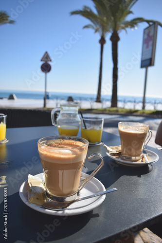 Healthy breakfast with coffee and orange juice in a cafe with a sea view