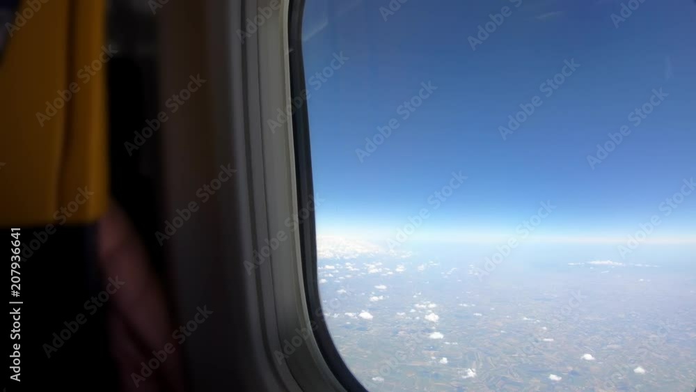 4K. Clouds seen through the window of airplane with the front seat. Travel in aircraft. POV of the passenger tourist traveling around the world-Adrian 4K. Clouds seen through the window of airplane with the front seat. Travel in aircraft. POV of the passenger tourist traveling around the world-Adrian