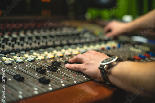 Hand of the mixing engineer on the audio console