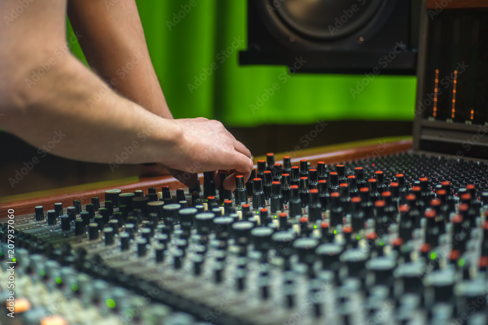 Hand of the mixing engineer on the audio console Hand of the mixing engineer on the audio console